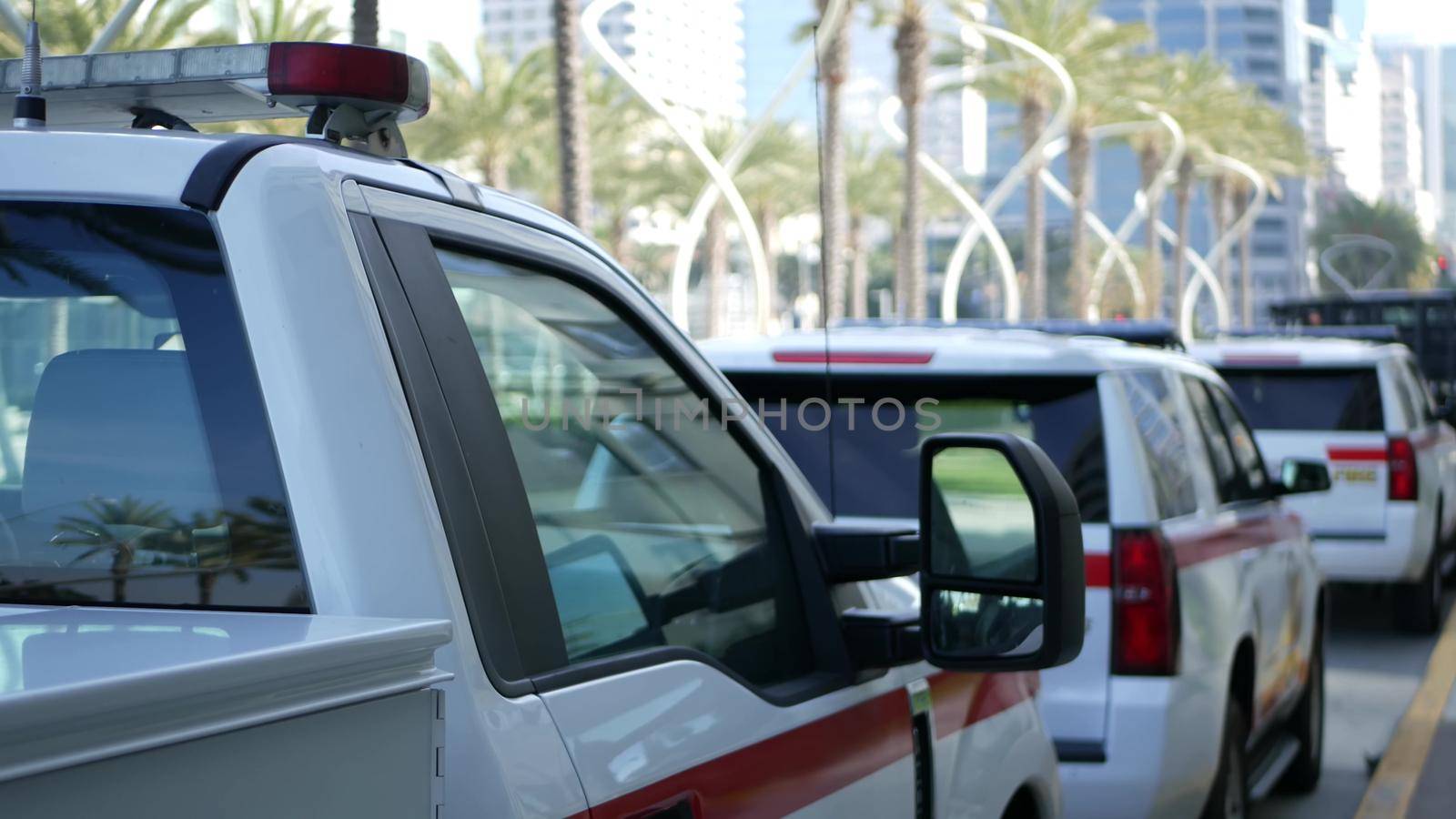 SAN DIEGO, CALIFORNIA USA - 15 JAN 2020: Fire department trucks and Sheriff's car with emergency sirens parked on Broadway. Firefighters vehicles in downtown. Fire engine for rescue and public safety.