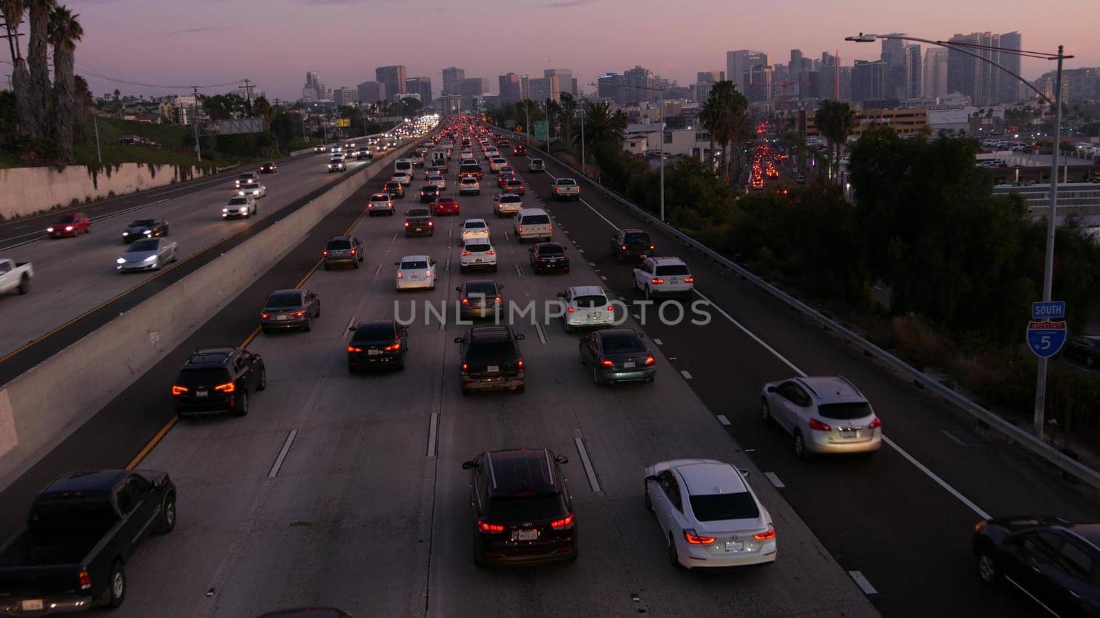 SAN DIEGO, CALIFORNIA USA - 15 JAN 2020: Busy intercity freeway, traffic jam on highway during rush hour. Urban skyline and highrise skyscrapers. Transportation concept and transport in metropolis by DogoraSun