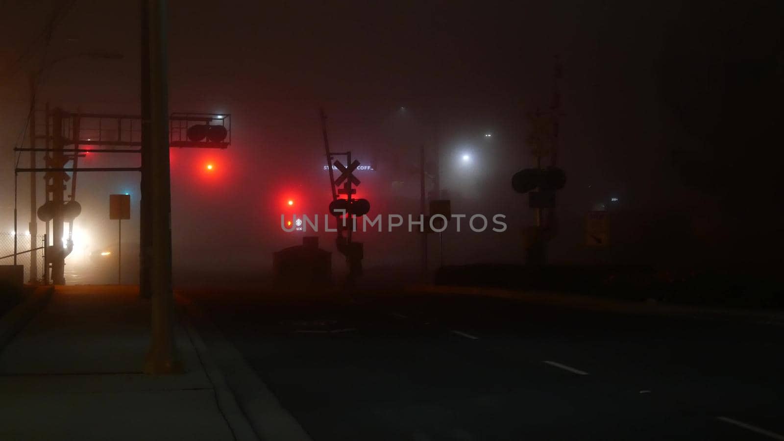 VISTA, CALIFORNIA USA - 24 JAN 2020: Marine layer, dense fog on driveway crossroad at night. June gloom, misty nebulous bad weather. Dangerous low visibility on road intersection. Car traffic safety by DogoraSun