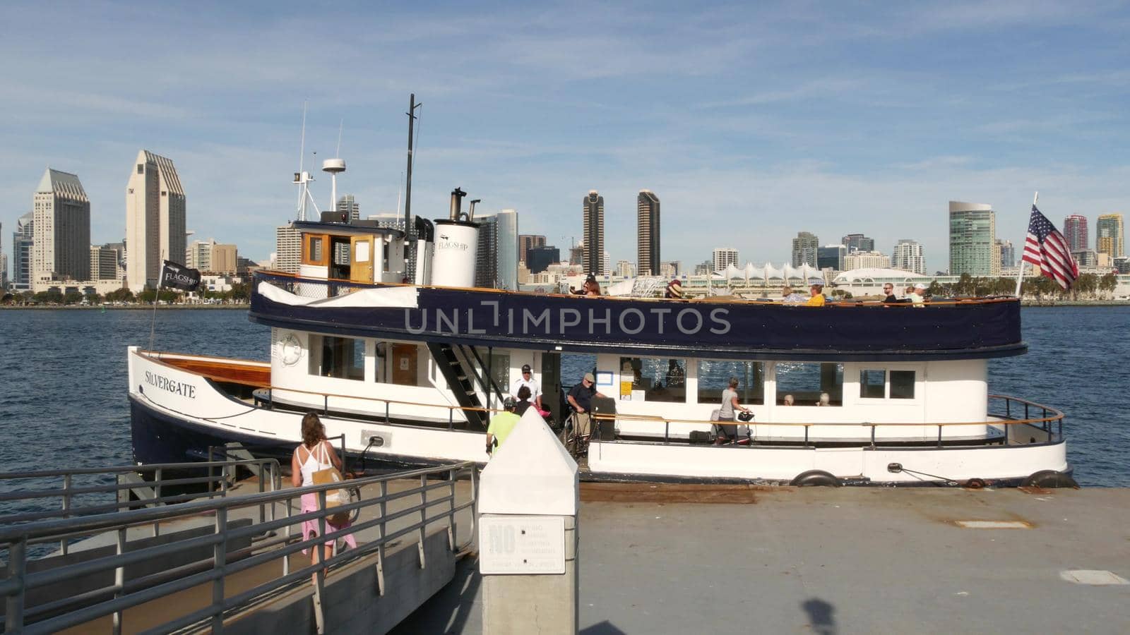 SAN DIEGO, CALIFORNIA USA - 30 JAN 2020: Silvergate passenger ferry boat near pier, Coronado island landing, Flagship public transportation. Metropolis urban skyline, highrise skyscrapers near harbor.