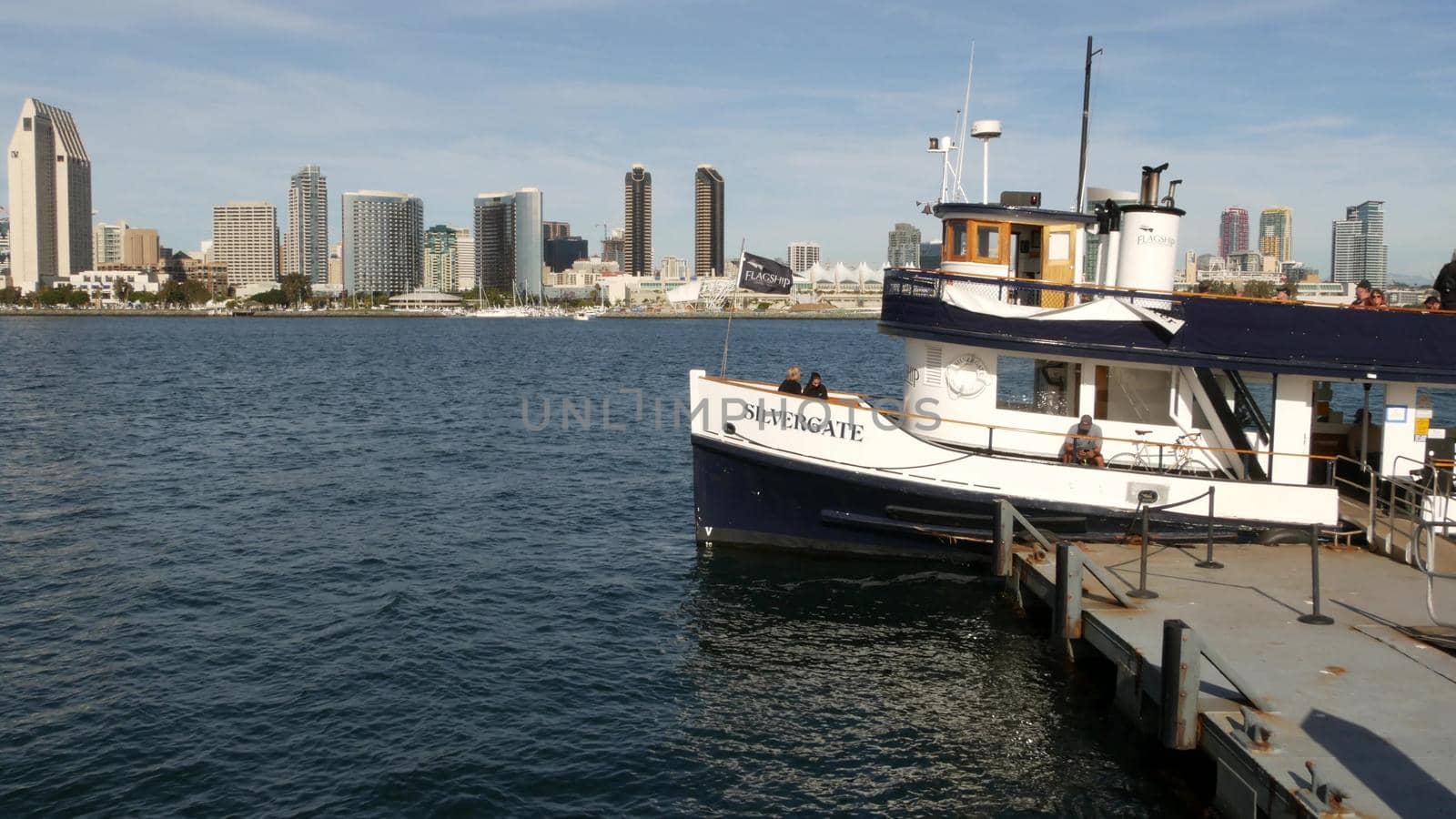 SAN DIEGO, CALIFORNIA USA - 30 JAN 2020: Silvergate passenger ferry boat near pier, Coronado island landing, Flagship public transportation. Metropolis urban skyline, highrise skyscrapers near harbor.