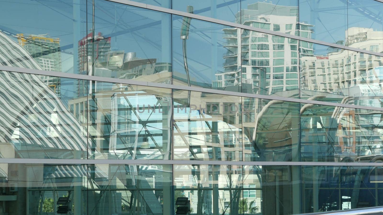 SAN DIEGO, CALIFORNIA USA - 13 FEB 2020: Contemporary Convention Center building, reflection of urban skyline in mirror glass wall. Highrise skyscrapers of Gaslamp Quarter in downtown of metropolis.