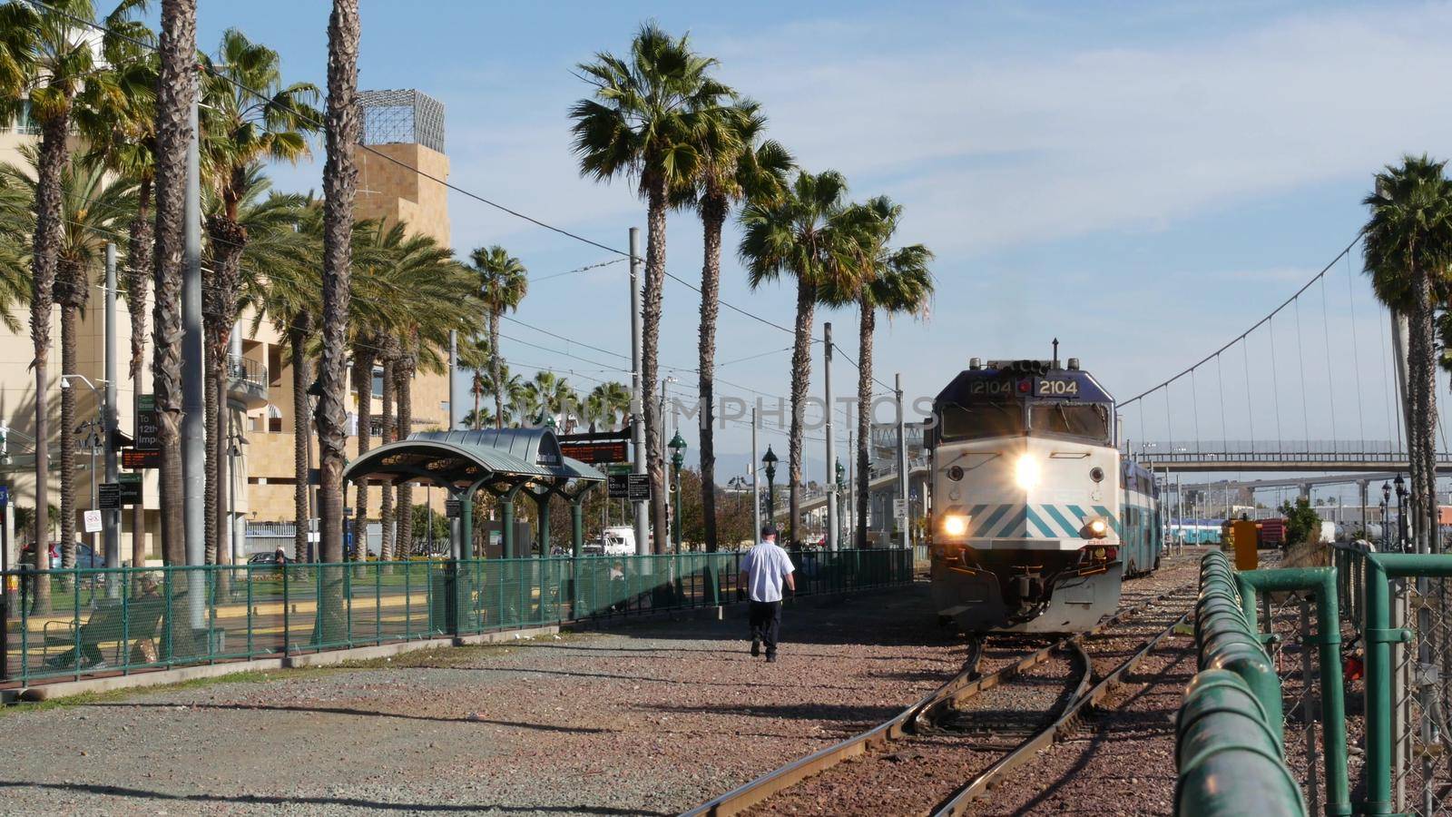 SAN DIEGO, CALIFORNIA USA - 13 FEB 2020: Coaster Commuter and palms, public rail transportation in America. Express passenger railway train, railroad nctd transport near Santa Fe station and Gaslamp.