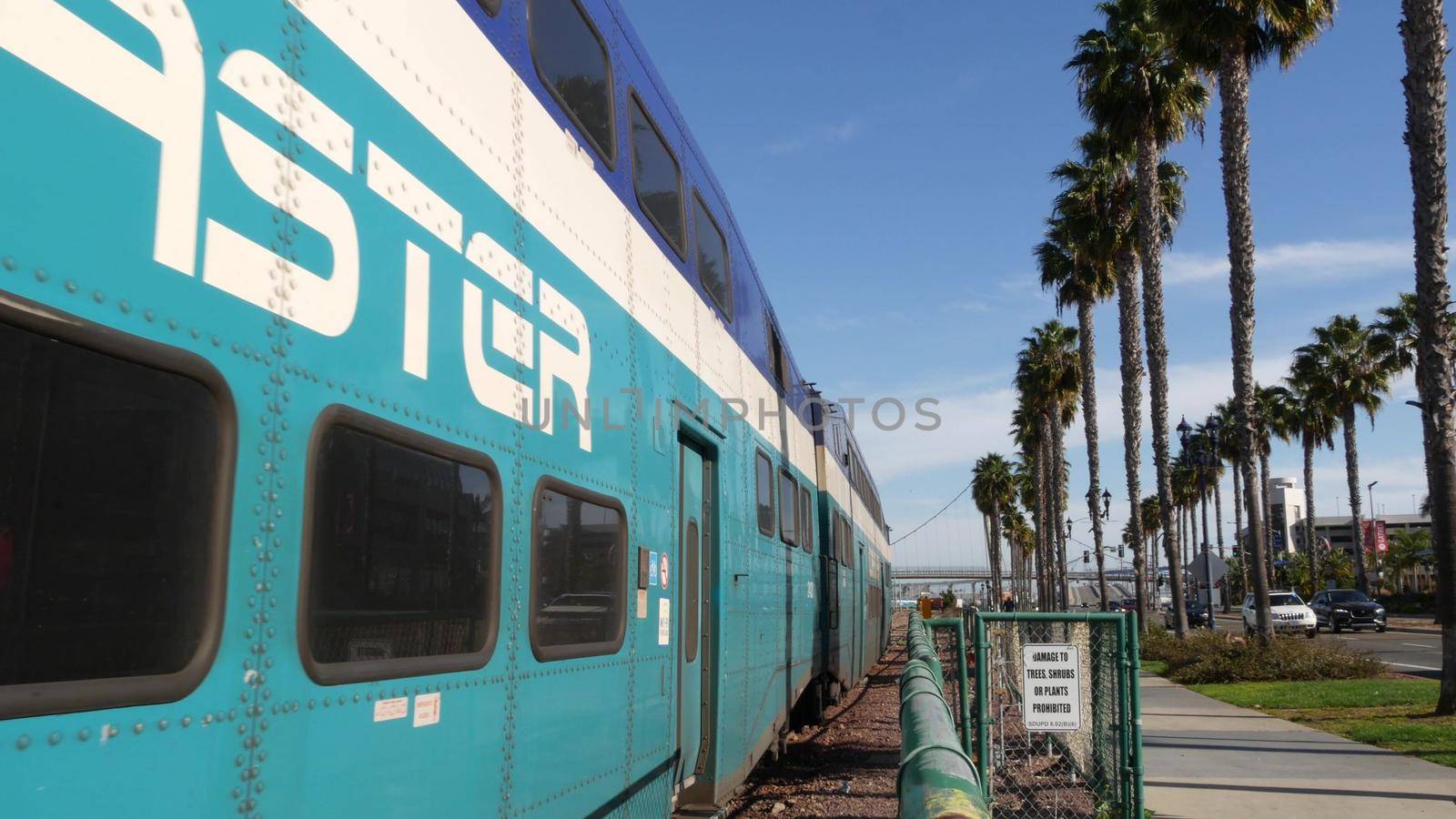 SAN DIEGO, CALIFORNIA USA - 13 FEB 2020: Coaster Commuter and palms, public rail transportation in America. Express passenger railway train, railroad nctd transport near Santa Fe station and Gaslamp by DogoraSun