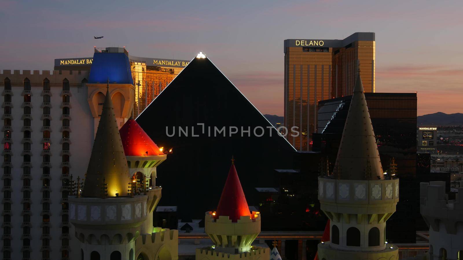 LAS VEGAS, NEVADA USA - 4 MAR 2020: Excalibur castle and Luxor pyramid casino uncommon aerial view. Plane flying from McCarran airport. Mandalay Bay and Delano hotel in american gambling sin city by DogoraSun