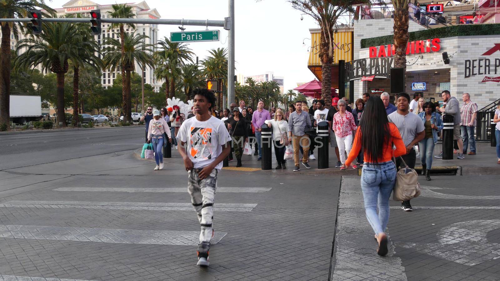 LAS VEGAS, NEVADA USA - 5 MAR 2020: People on pedestrian walkway. Multicultural men and women walking on city promenade. Crowd of citizens on sidewalk. Diversity of multiracial faces in metropolis by DogoraSun