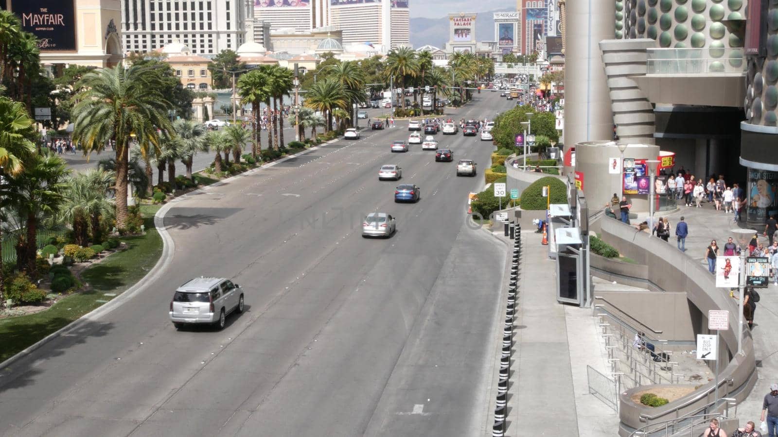 LAS VEGAS, NEVADA USA - 7 MAR 2020: The Strip boulevard with luxury casino and hotels in gambling sin city. Car traffic on road to Fremont street in tourist money playing resort. People walking by DogoraSun