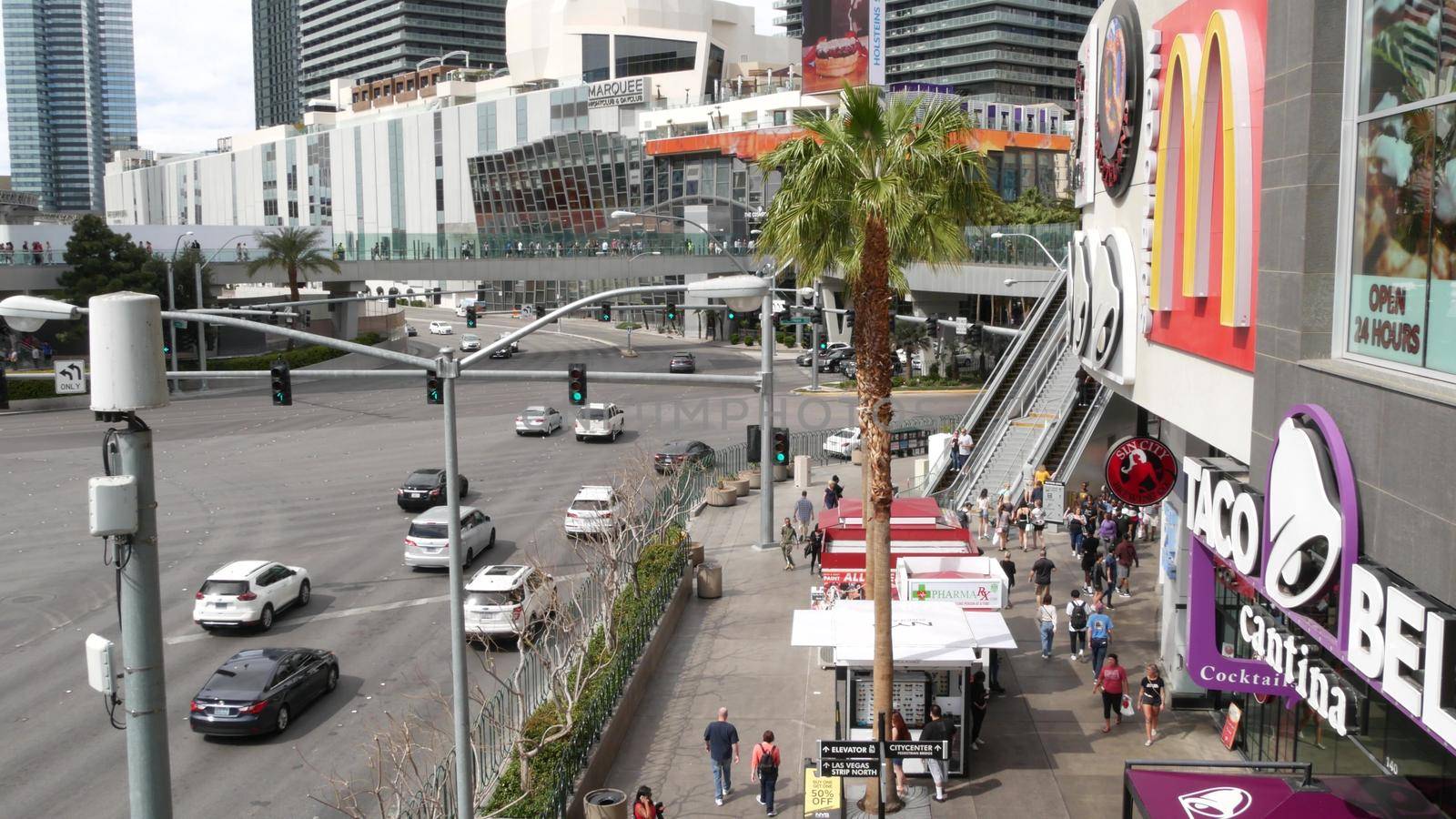 LAS VEGAS, NEVADA USA - 7 MAR 2020: The Strip boulevard with luxury casino and hotels in gambling sin city. Car traffic on road to Fremont street in tourist money playing resort. People and McDonalds by DogoraSun