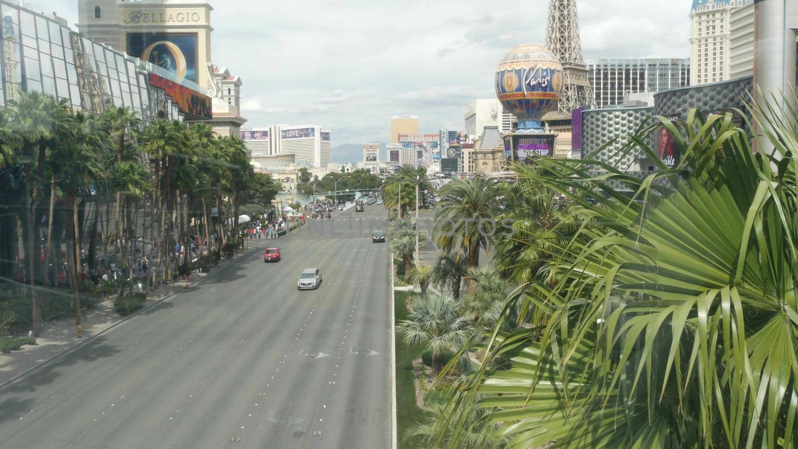LAS VEGAS, NEVADA USA - 7 MAR 2020: The Strip boulevard with luxury casino and hotels in gambling sin city. Car traffic on road to Fremont street in tourist money playing resort. People walking by DogoraSun