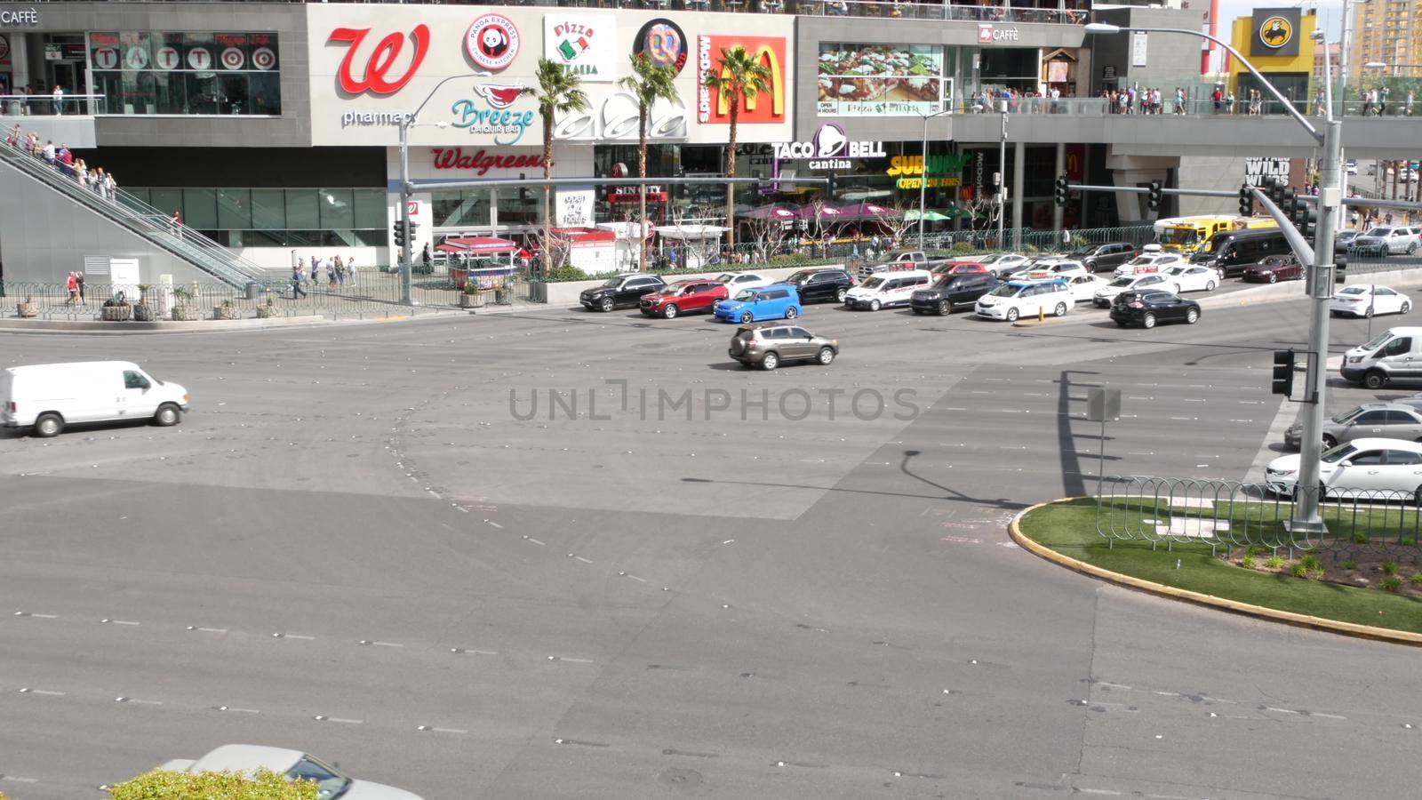 LAS VEGAS, NEVADA USA - 7 MAR 2020: The Strip boulevard with luxury casino and hotels in gambling sin city. Car traffic on road to Fremont street in tourist money playing resort. People and McDonalds by DogoraSun