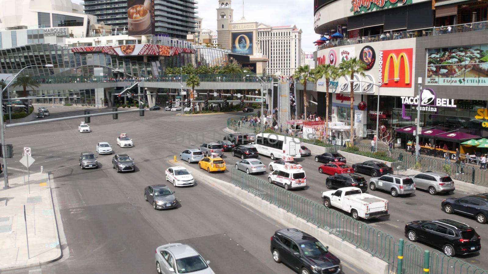 LAS VEGAS, NEVADA USA - 7 MAR 2020: The Strip boulevard with luxury casino and hotels in gambling sin city. Car traffic on road to Fremont street in tourist money playing resort. People and McDonalds by DogoraSun