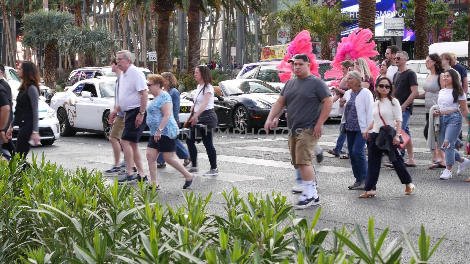 LAS VEGAS, NEVADA USA - 7 MAR 2020: People on pedestrian walkway. Multicultural men and women walking on city promenade. Crowd of citizens on sidewalk. Diversity of multiracial faces in metropolis by DogoraSun