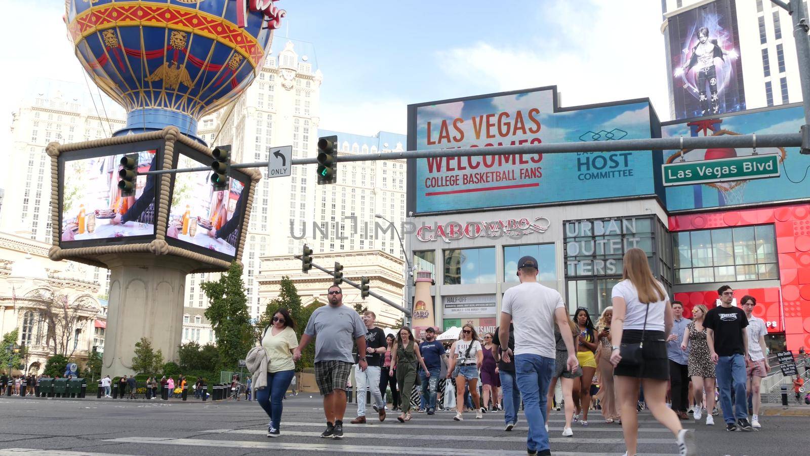 LAS VEGAS, NEVADA USA - 7 MAR 2020: People on pedestrian walkway. Multicultural men and women walking on city promenade. Crowd of citizens on sidewalk. Diversity of multiracial faces in metropolis by DogoraSun