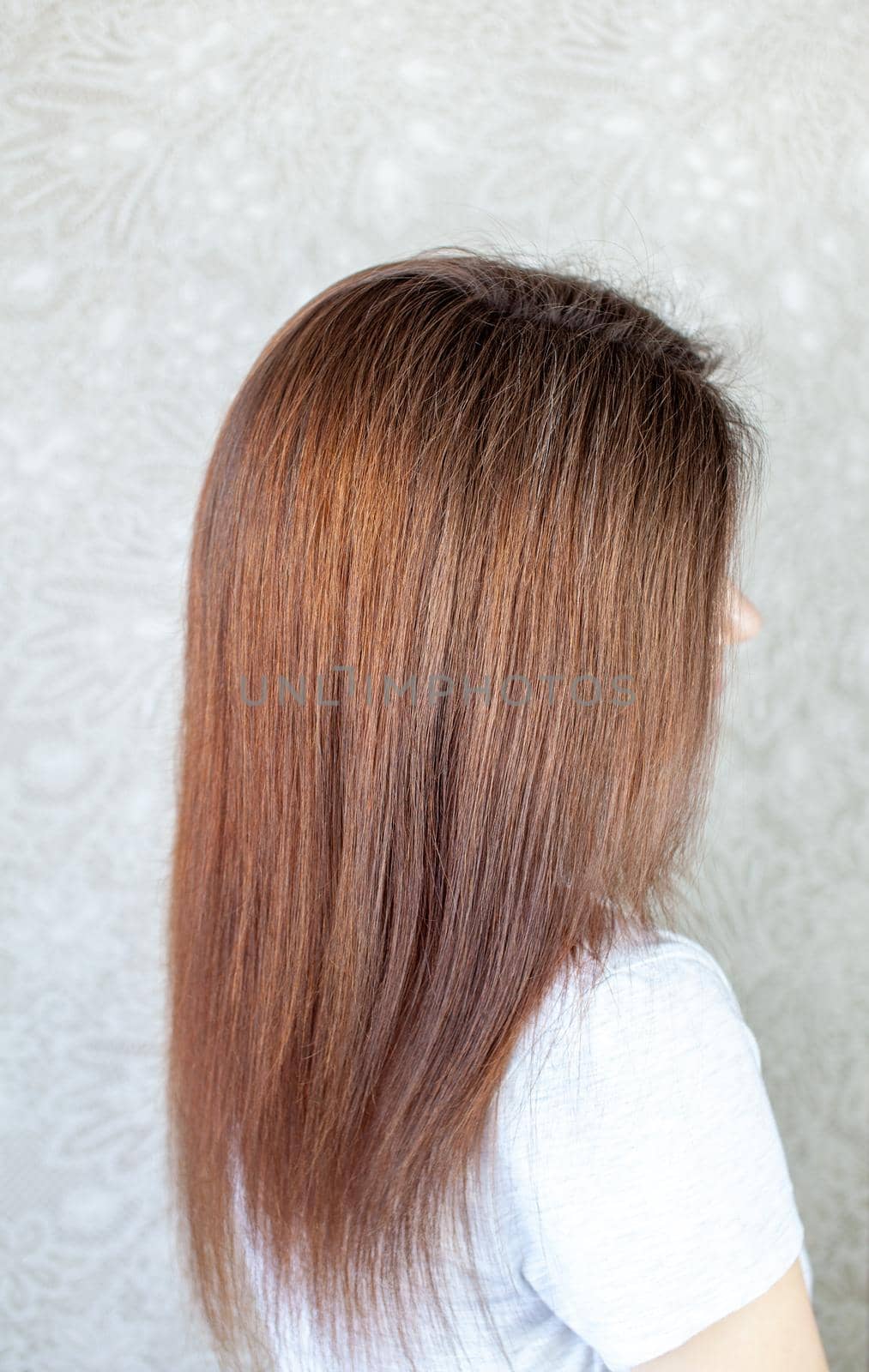 A girl with long, straight and beautiful brown hair. Hair care at home.