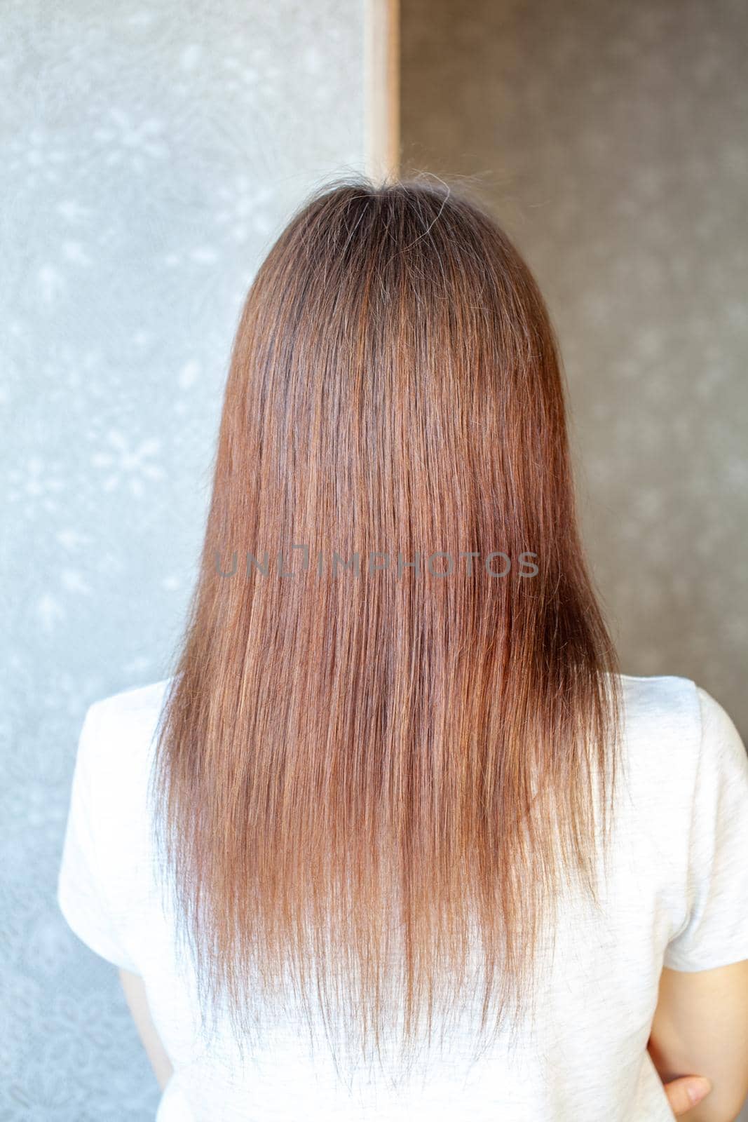 A girl with long, straight and beautiful brown hair. Hair care at home by AnatoliiFoto