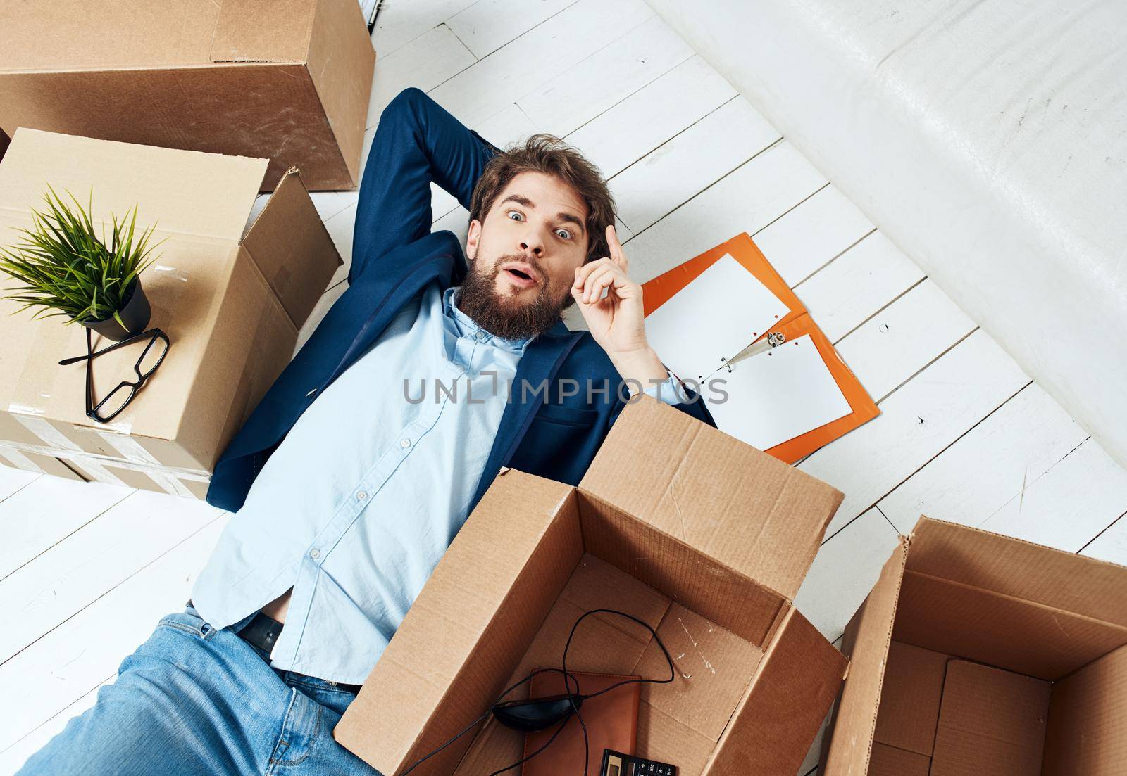 man lying on the floor with documents office box with things professional unpacking. High quality photo