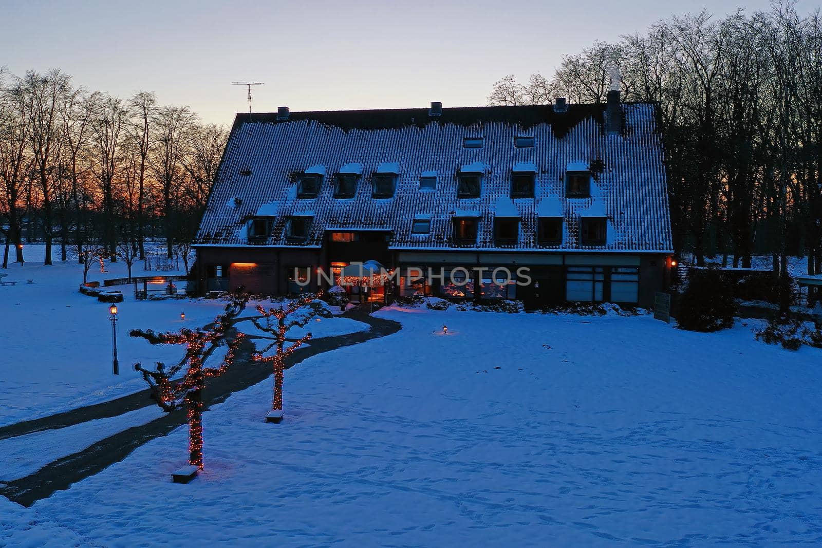 Traditional snowy farm house in winter in the countryside from the Netherlands at sunset