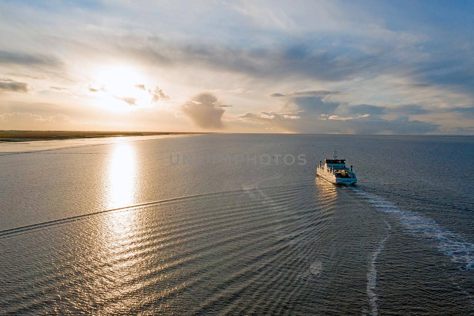 Aerial from the ferry from Ameland arriving at Holwerd in the Netherlands at sunset