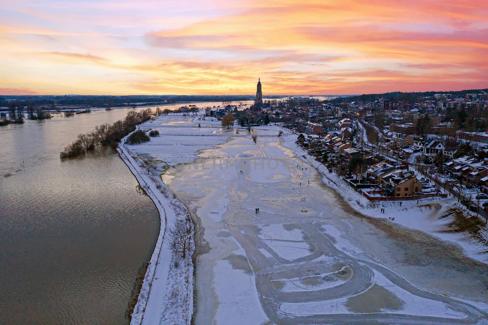 Aerial from the snowy city Rhenen in the Netherlands in winter at sunset