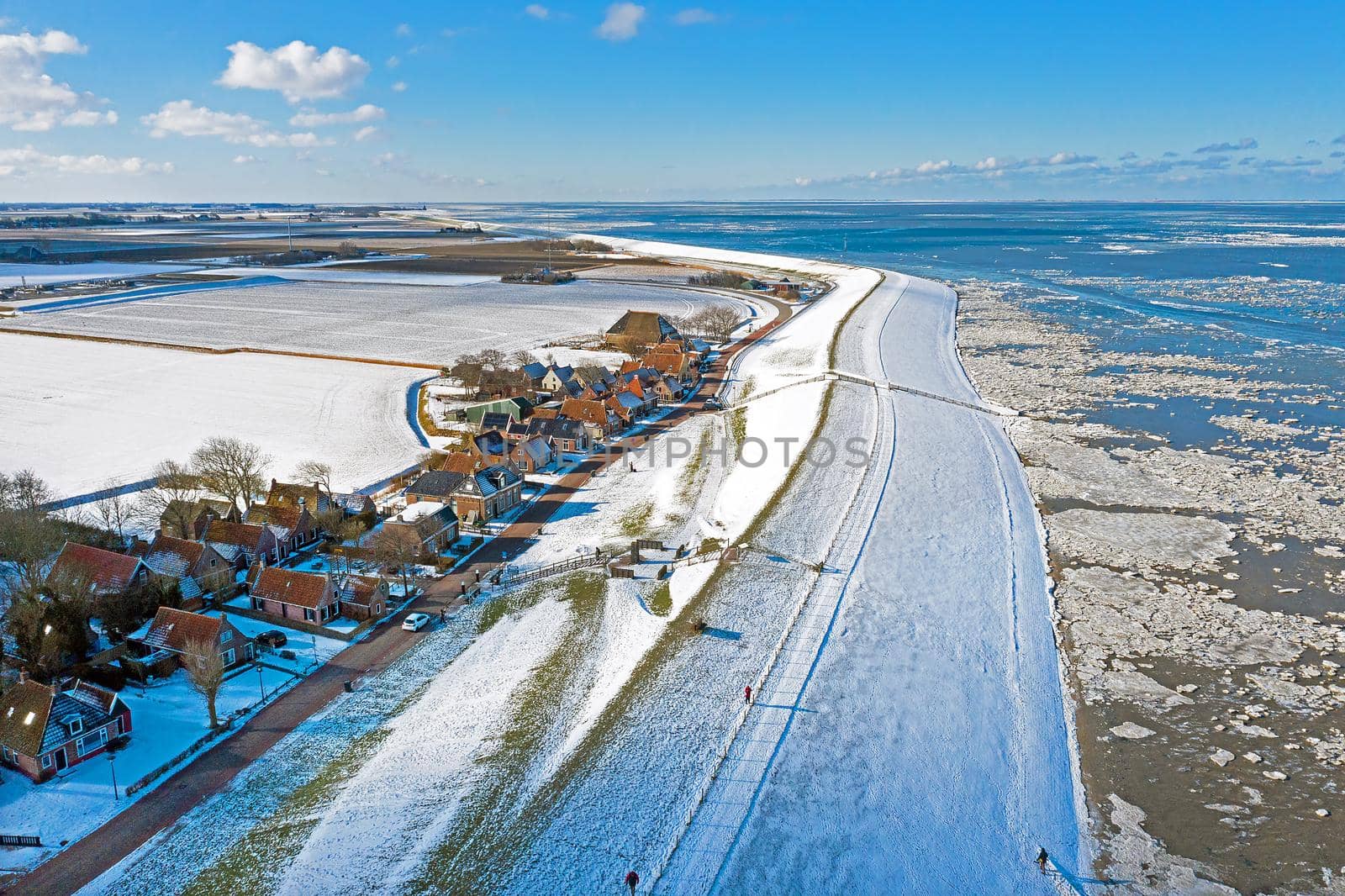 Aerial from the snowy village Moddergat at the frozen Waddensea in winter in the Netherlands