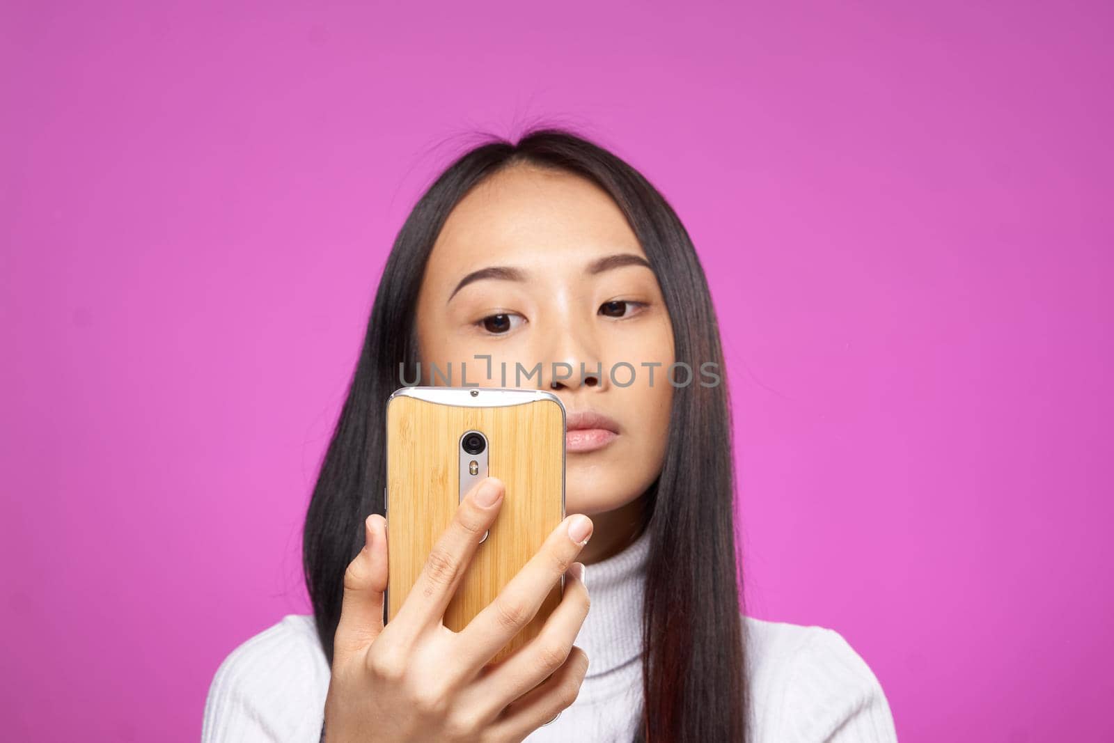 pretty woman with phone in hand internet technology messages pink background. High quality photo