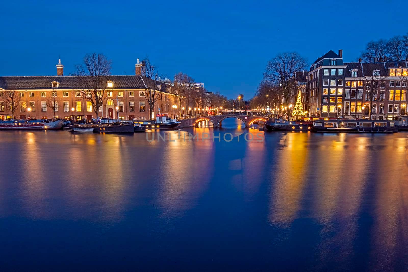 City scenic from Amsterdam by night at the river Amstel in the Netherlands