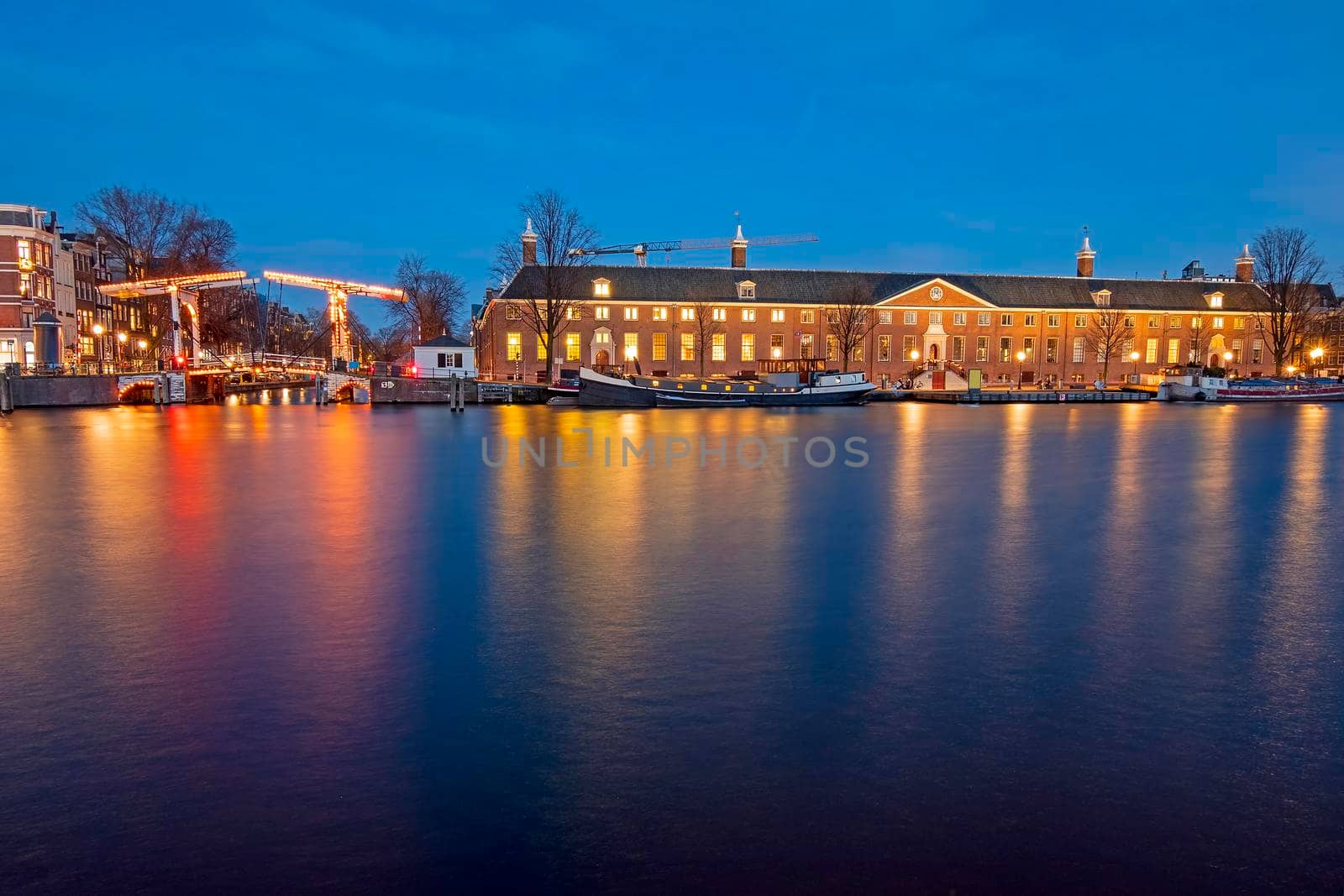 City scenic from Amsterdam by night at the river Amstel in the Netherlands