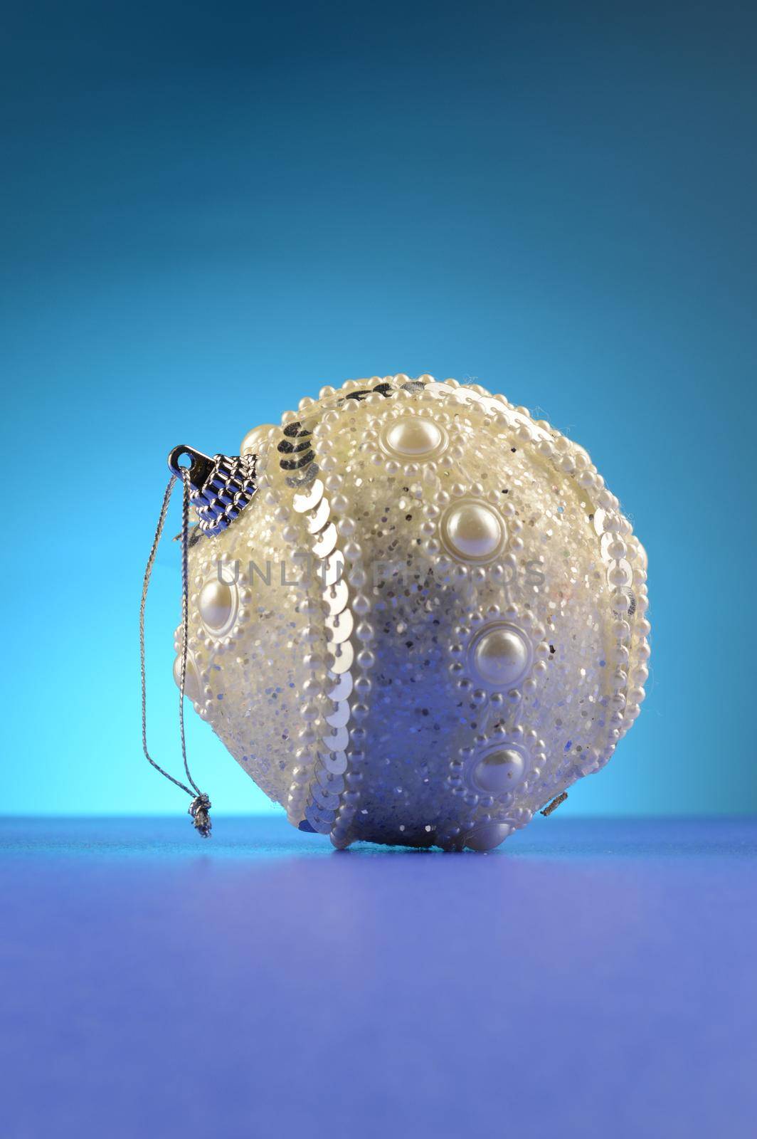 A white Christmas bauble over a cool blue background.