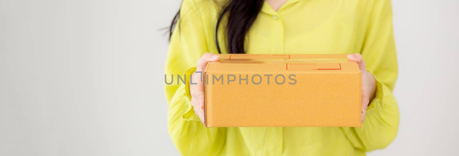 Young asian woman holding cardboard box at home, happy female carrying parcel box giving, present and gift, packaging for deliver, online shopping store and service concept.