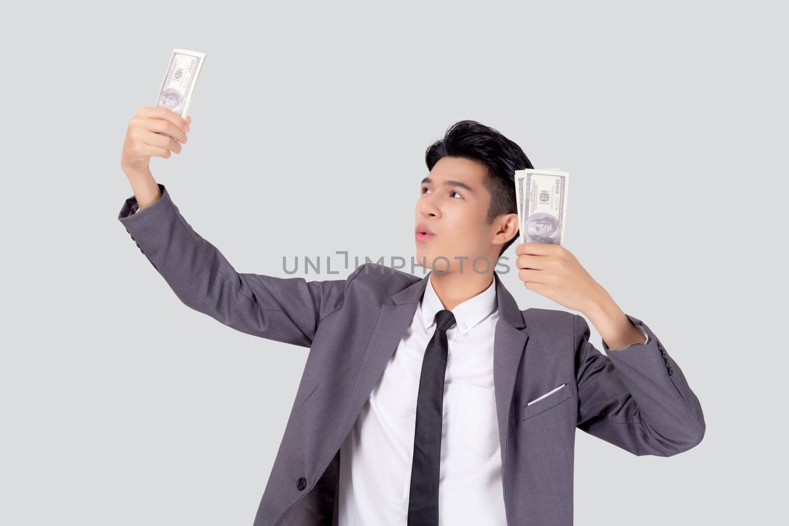 Young asian business man holding money dollar isolated on white background, businessman in suit holding banknote and success and excited with finance, savings and investment, income and spending.