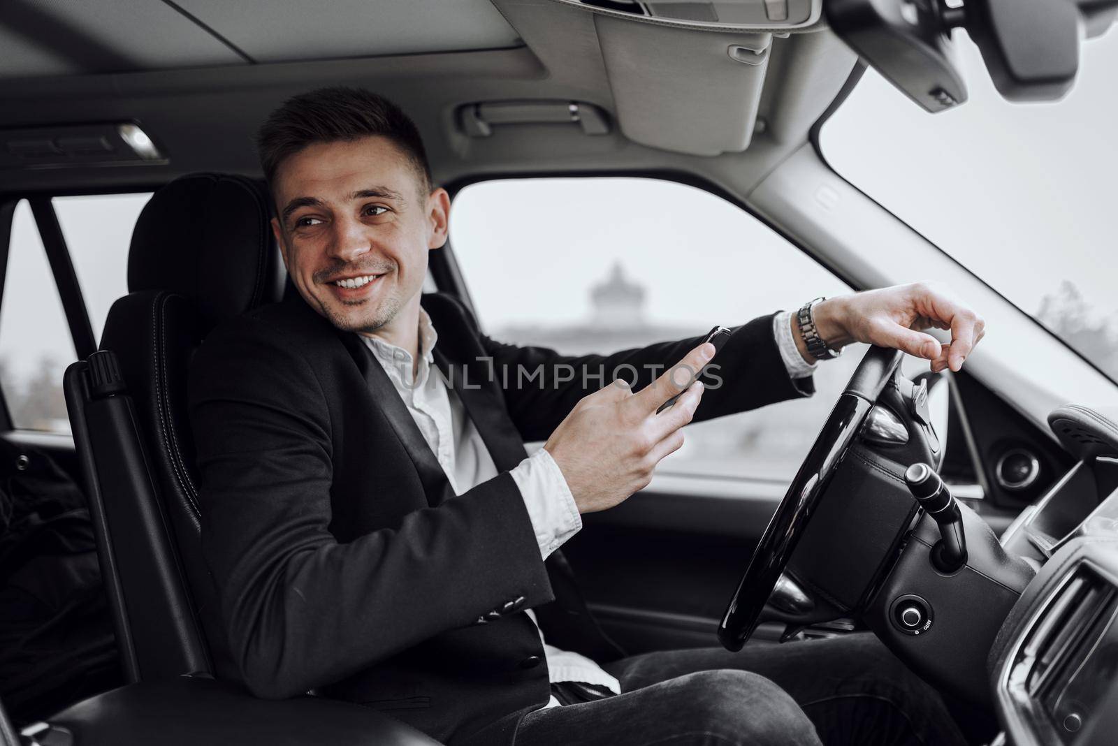 Waist up of smiling handsome man renting automobile and using smartphone. Rent and trade-in concept