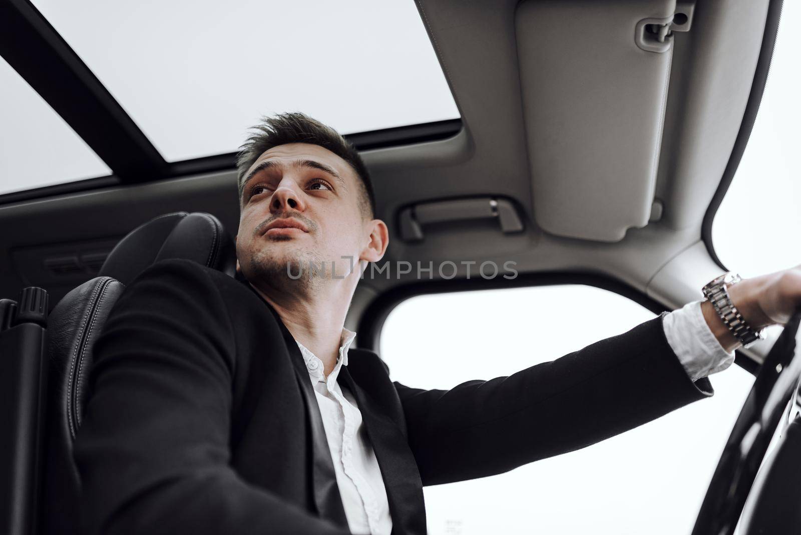 Businessman driving through the city during his morning by monakoartstudio