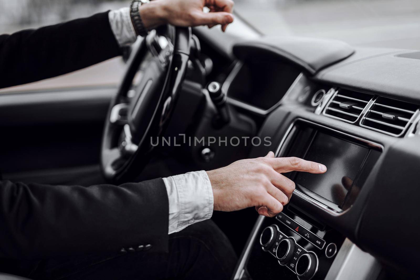 Close up of man driving car with audio stereo system on board computer. Transportation and vehicle concept