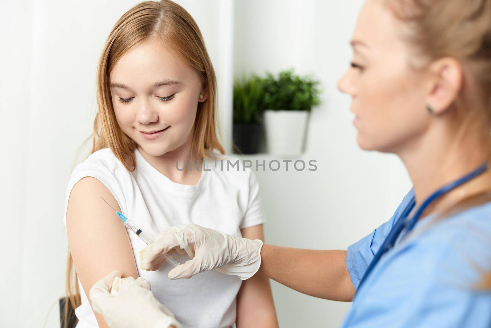 woman doctor giving a girl an injection in the arm vaccination. High quality photo