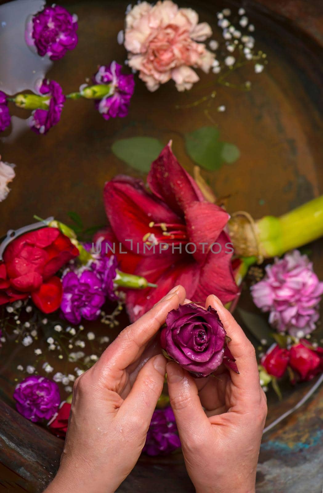 Various flowers on dark vintage background, big flower in hand by aprilphoto