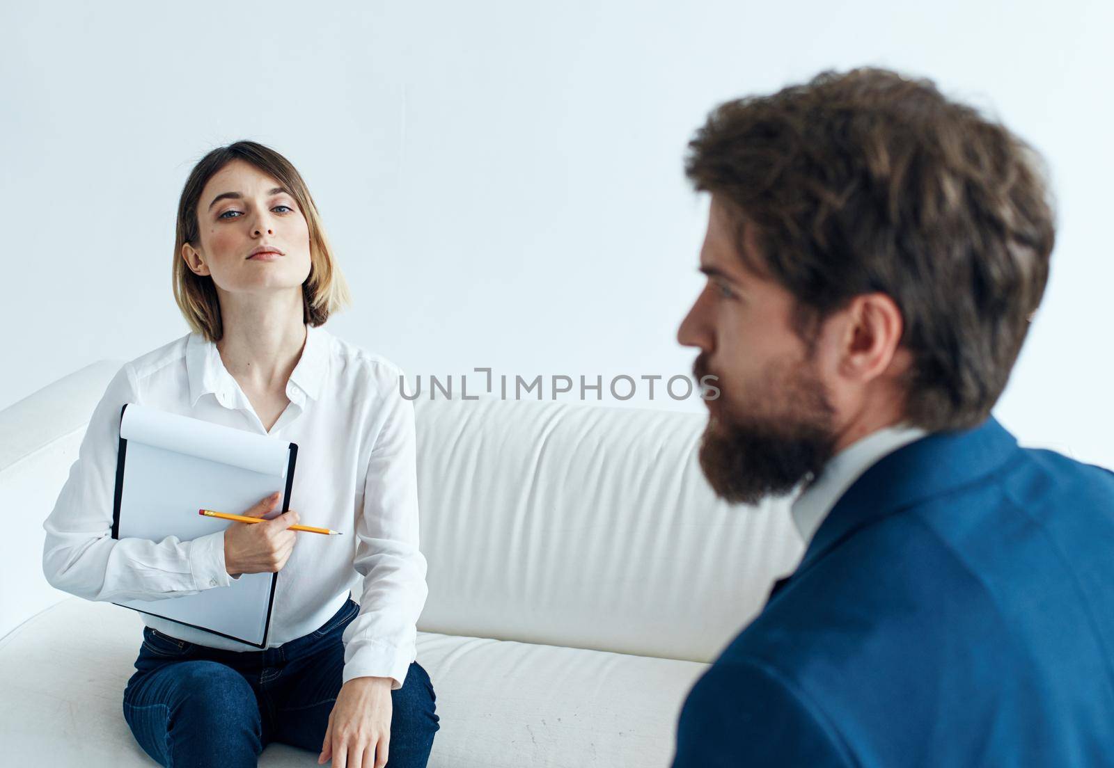 Business man in a classic suit and a woman on the couch with documents in their hands. High quality photo