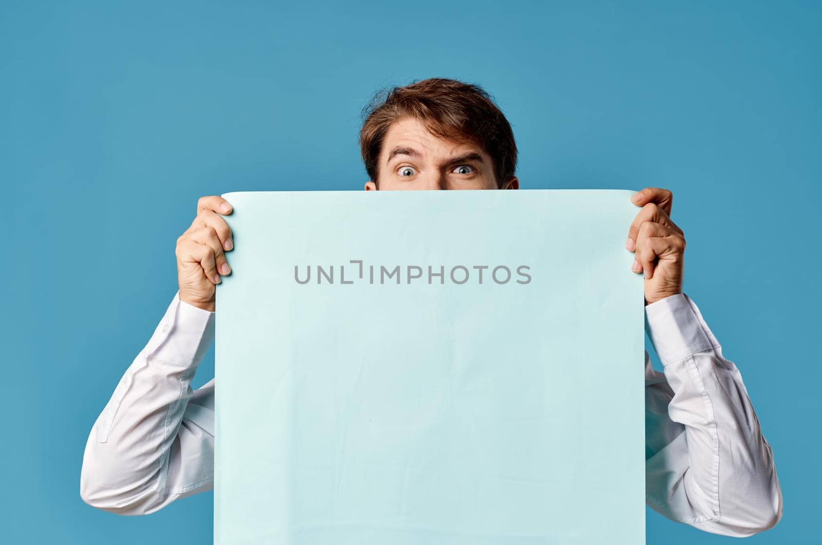 bearded man holding a banner advertising blue background in front of him. High quality photo