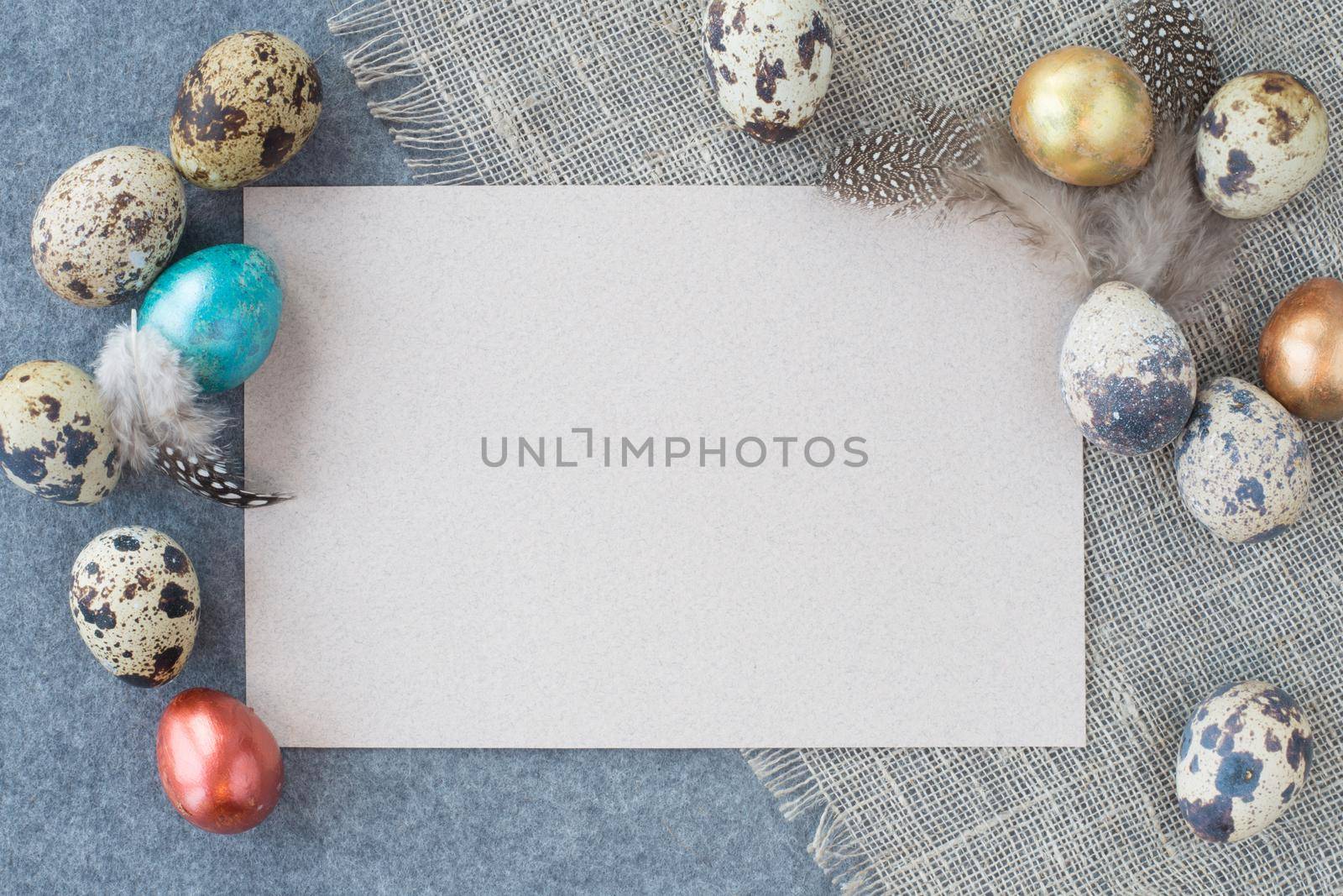 Easter greeting card with copy space for text and beautiful decor of eggs and feathers on fabric background pastel colored template for design