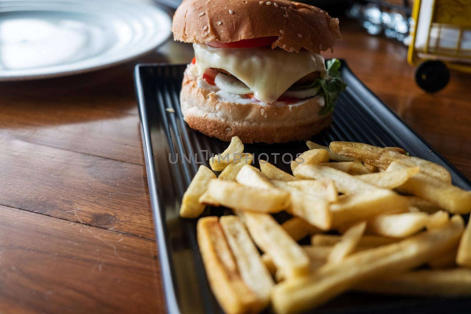 Tasty hamburger with french fries on wooden table