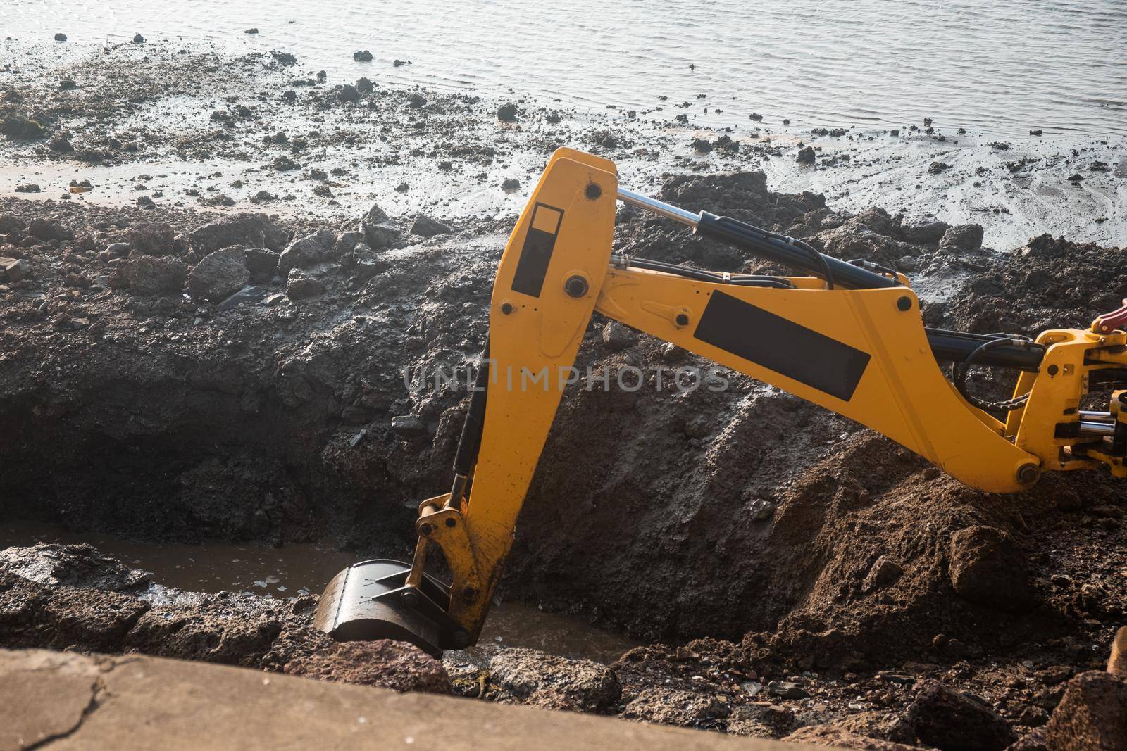Excavator at a construction site near coastline