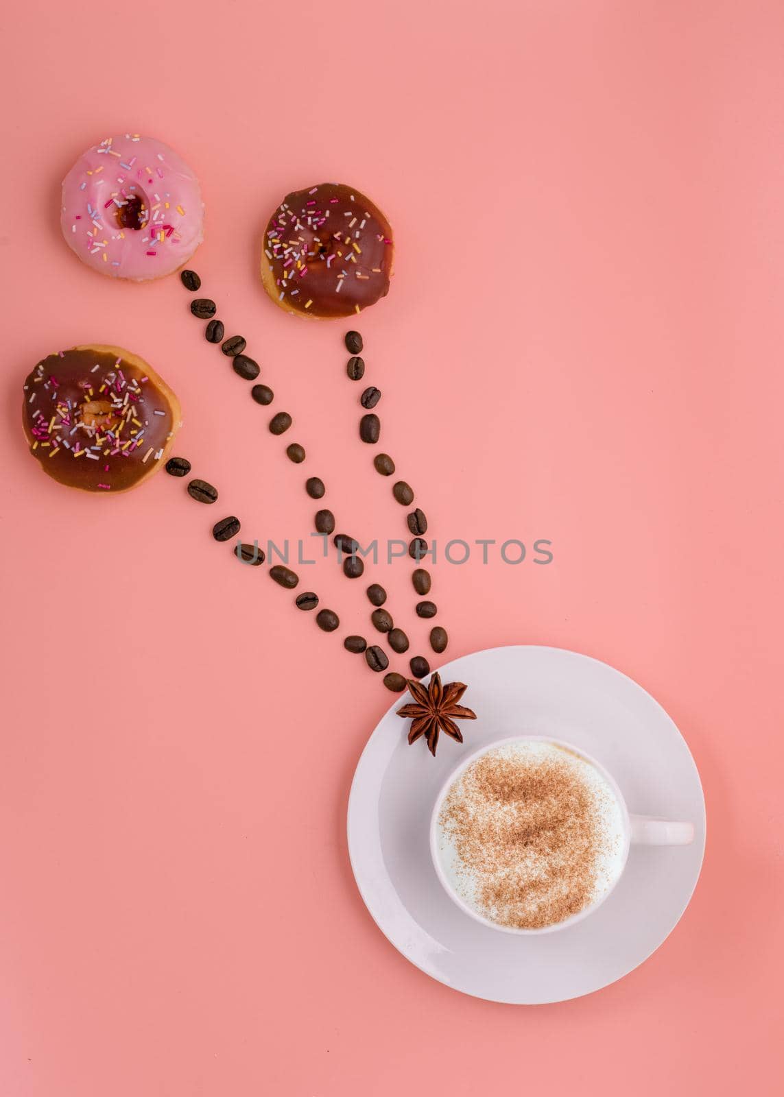 cup of coffee, beans and three doughnut on pink background