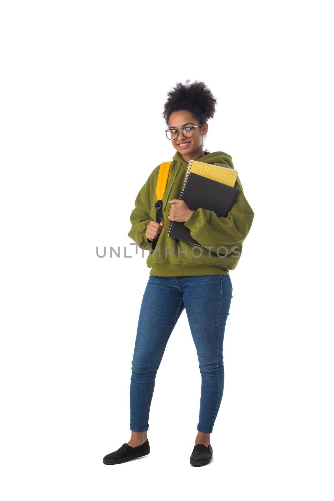 Friendly ethnic black female high school student in eyeglasses with backpack and composition book isolated on white background, full length portrait