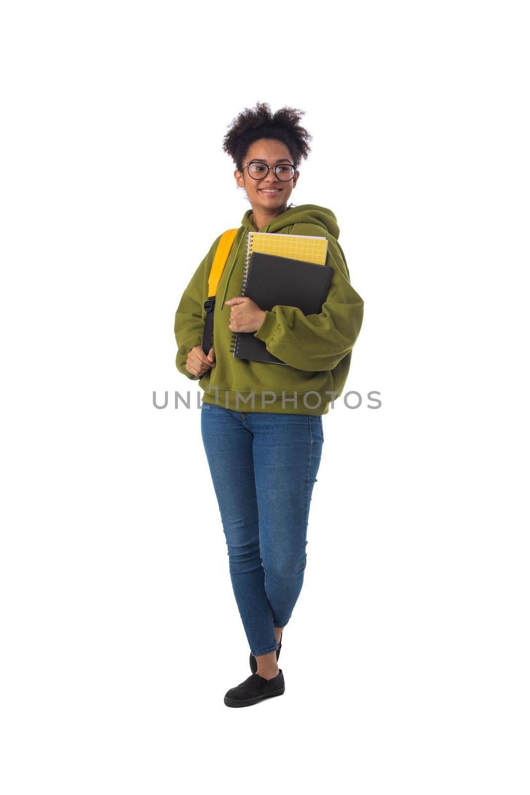 Friendly ethnic black female high school student in eyeglasses with backpack and composition book isolated on white background, full length portrait