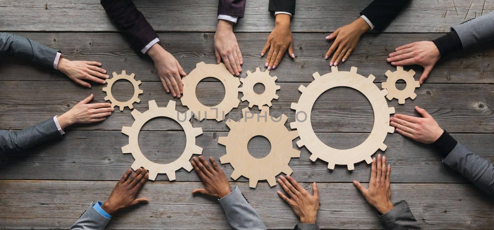 Business people connect golden gear together at meeting table, success cooperation teamwork concept