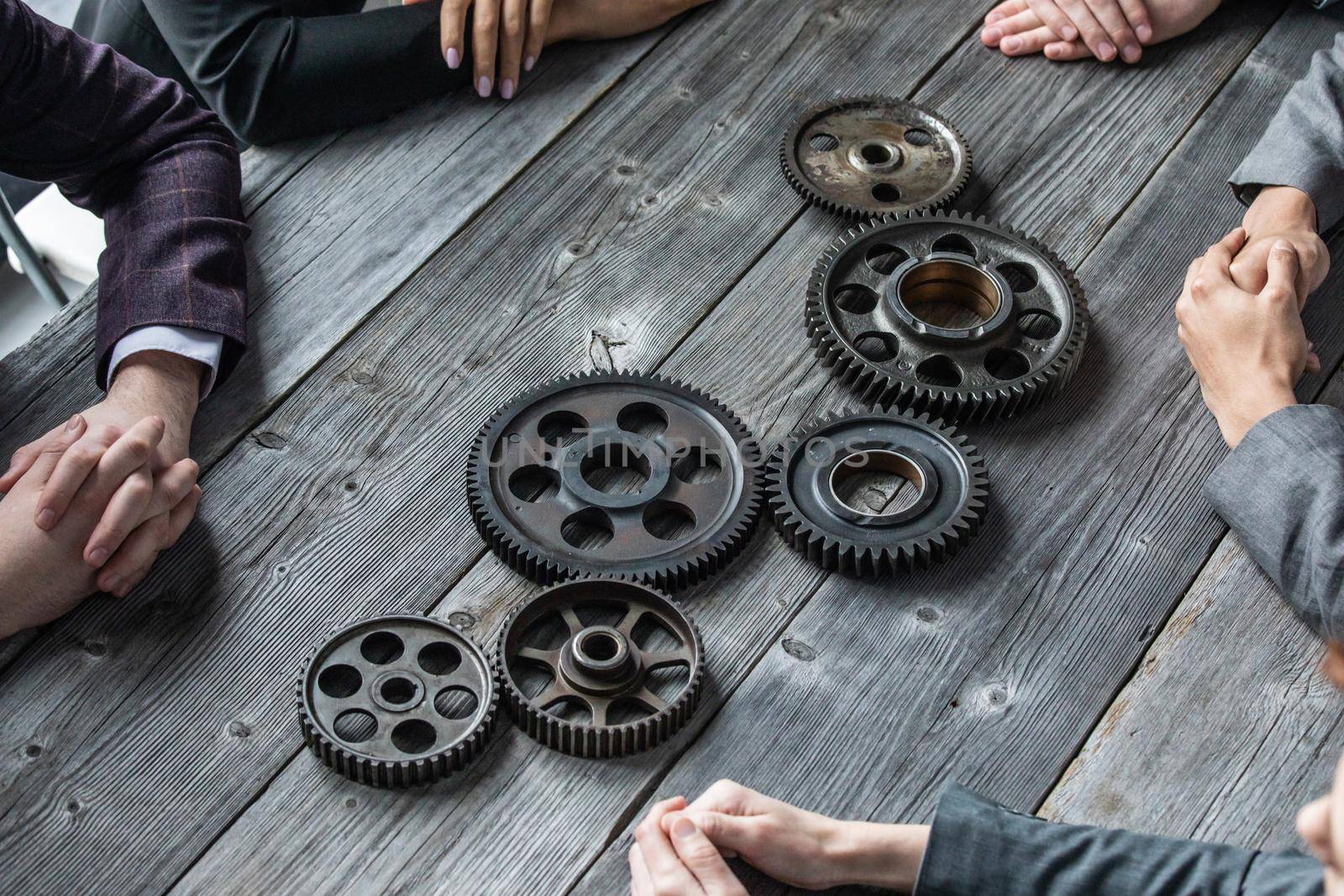 Business people connect gear together at meeting table, success cooperation teamwork concept