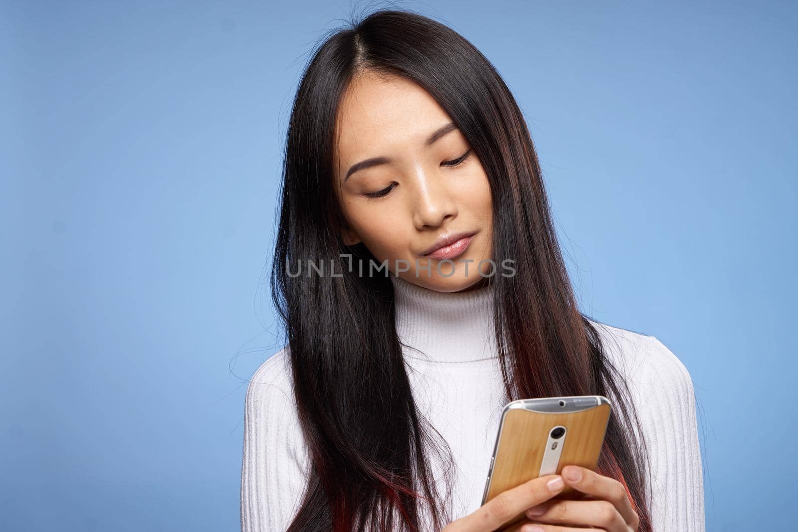 woman asian appearance phone hands communication technology lifestyle blue background by SHOTPRIME