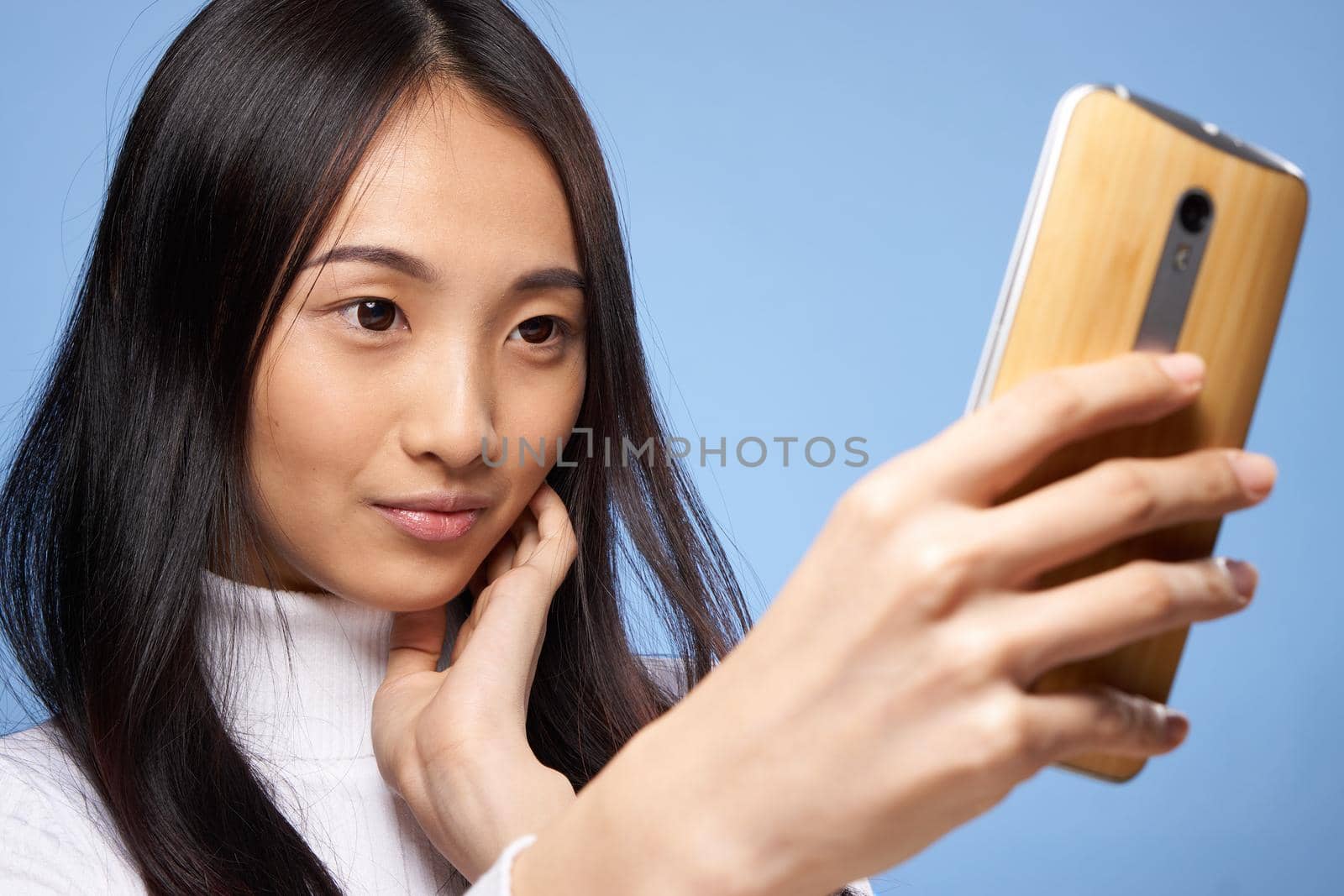 pretty brunette with a phone in her hands the charm of internet communication technology close-up by SHOTPRIME