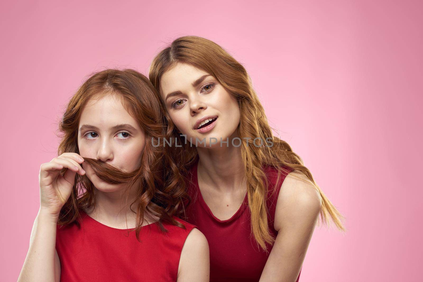 Mom and daughter fun communication family joy pink background cropped view. High quality photo