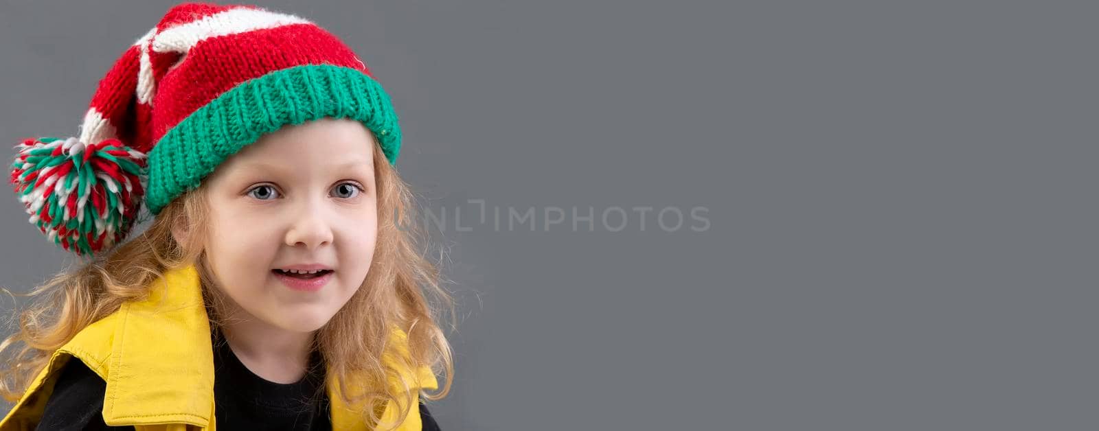 Funny little girl in a Christmas hat. by Sviatlana