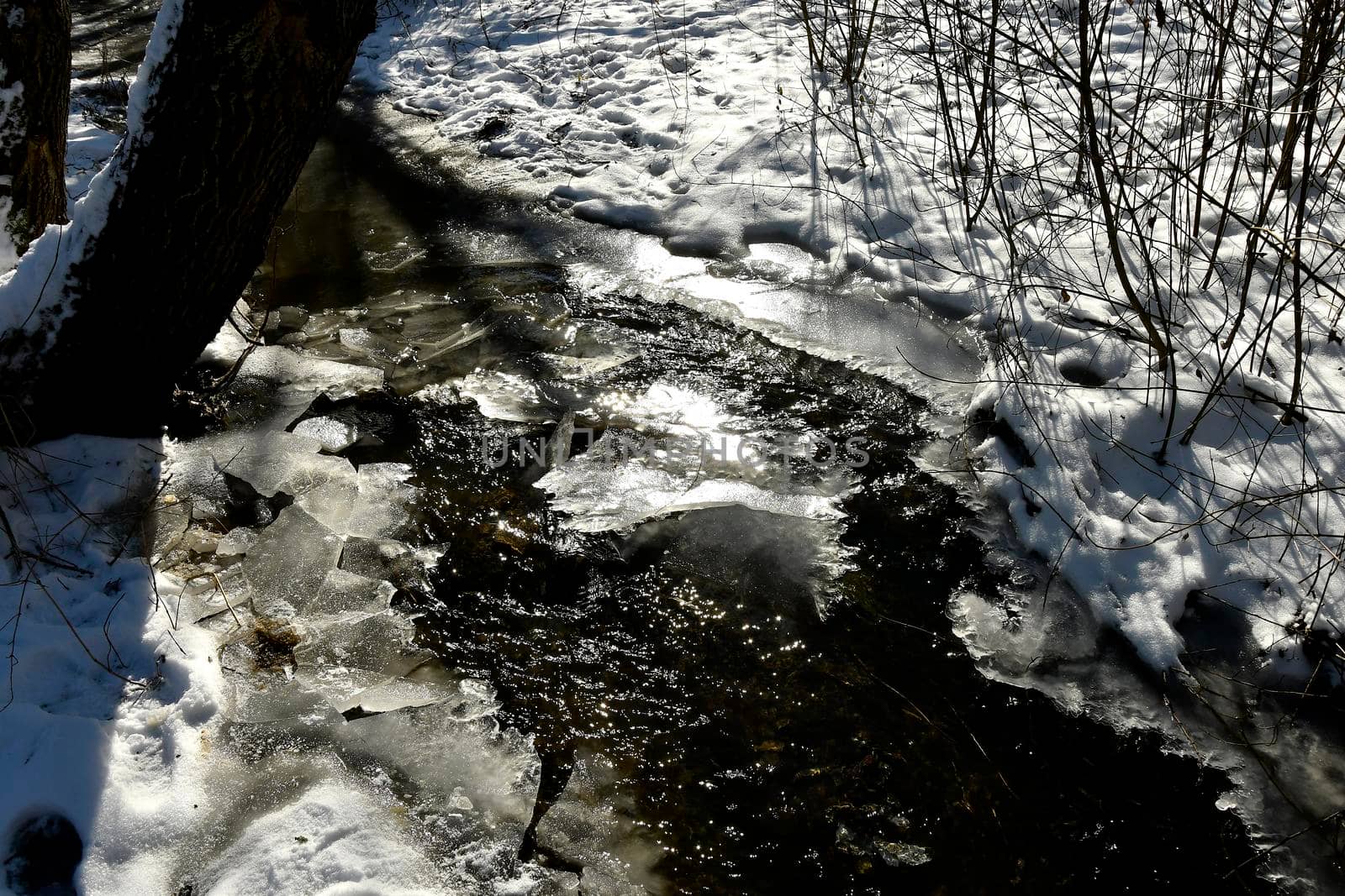 little creek in wiinter with ice in back light by Jochen